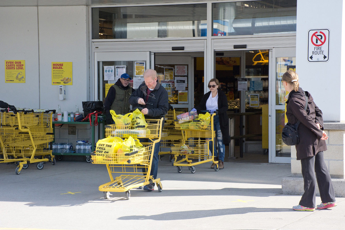 Man with blue cap is policing entrance at No Frills